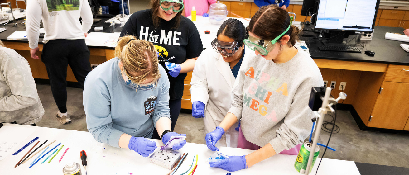 students working at a table in a chemisry lab with beakers