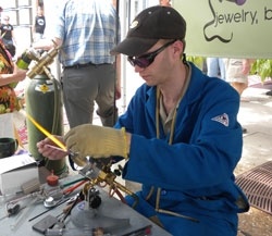 man glassblowing at a festival