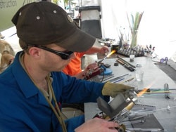 man glassblowing at a festival