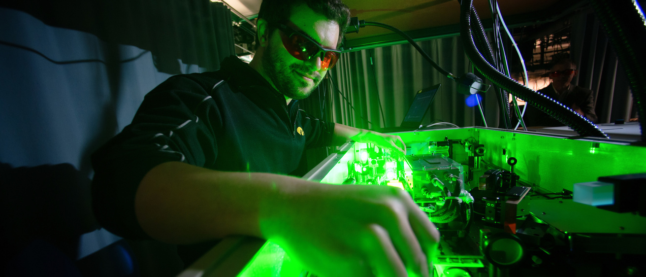 chemistry student in lab with green glowing light