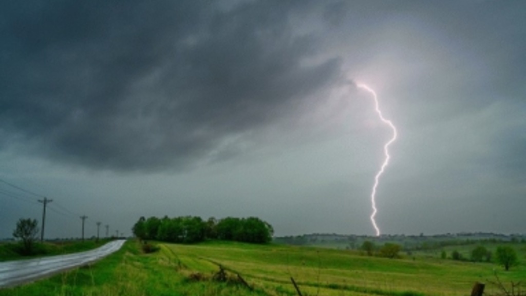 An image of a storm with lightning hitting the ground of a rural scenery. 